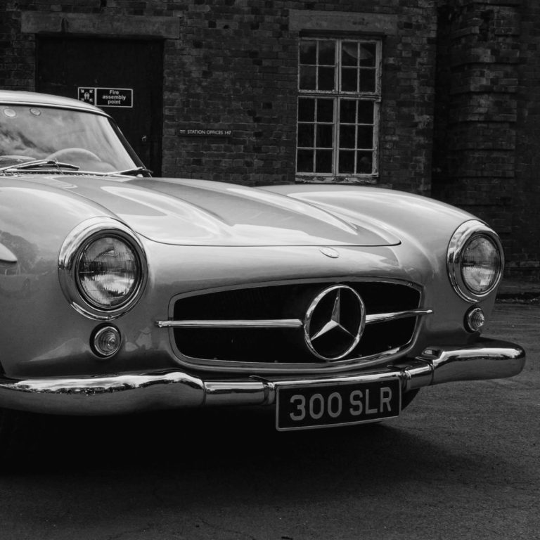 Oldtimer Silberner Mercedes 300 SLR mit klassischem Design und glänzendem Kühlergrill.